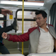 Simu Liu's Shang-Chi punches a thug flying as his friend Katy (Awkwafina) watches.